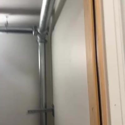 New galvanised dry riser pipework and a landing valve fitted beside a doorway