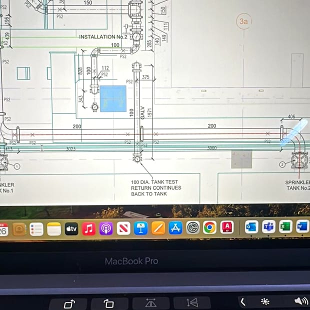A sprinkler installation drawing open on a laptop on site