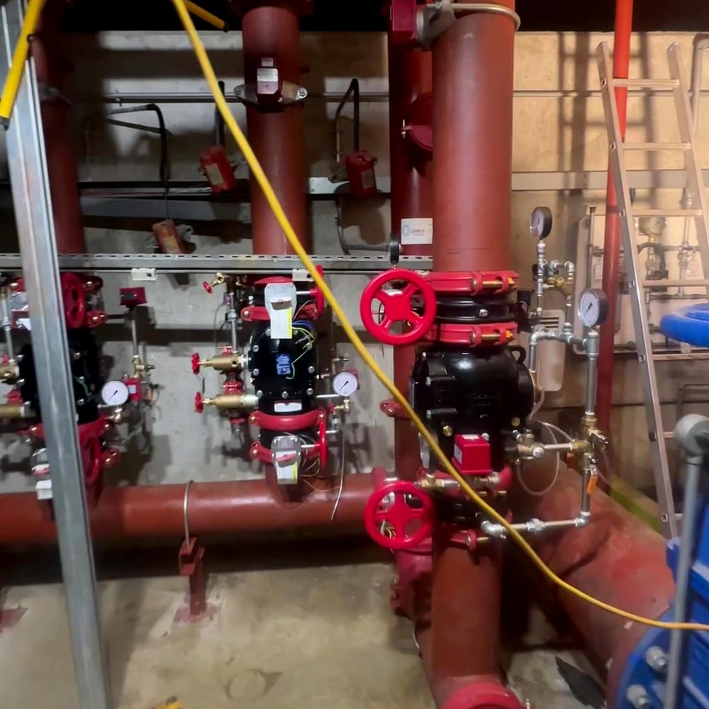 A valve assembly and red pipework in a pump house, the kind of plant fire pump replacement involves